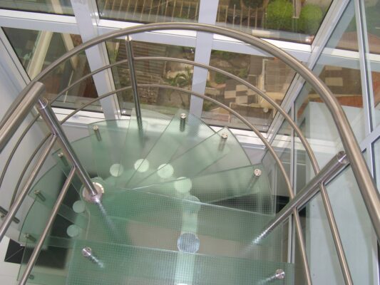 Escada de vidro e metal em um espaço moderno.