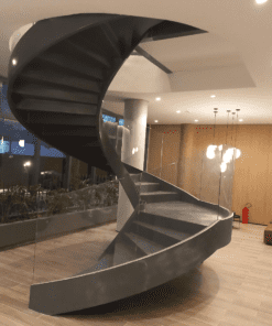 Escada helicoidal com guarda corpo de vidro curvo executada por Escadas Especiais em um ambiente hall de entrada principal de uma edifício residencial