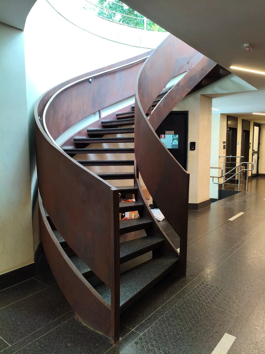 Escada helicoidal metálica de alto padrão em aço corten com linguagem contemporânea