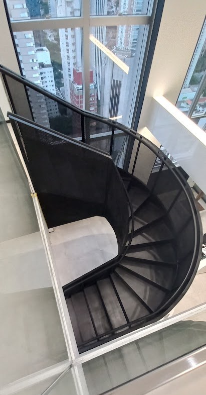 Espiral completa da escada helicoidal em aço preto vista do pavimento superior